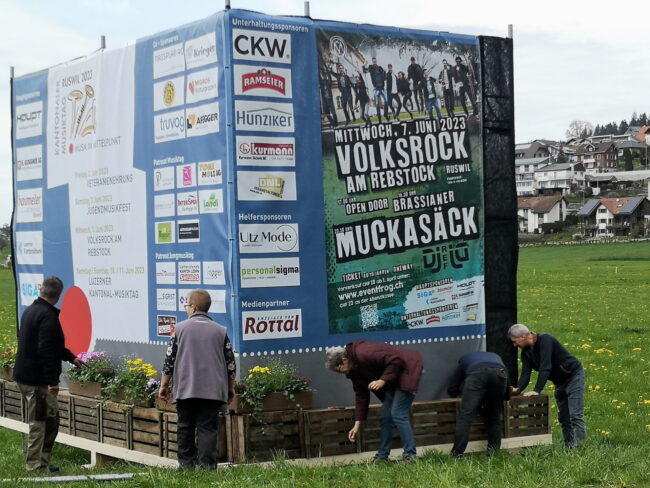 Fotos Aufbau Musiktag: Die Intensiv-Phase beginnt mit dem aufstellen der Werbetafeln für den Musiktag Ruswil 2023. Auch Blumen gehören dazu.
