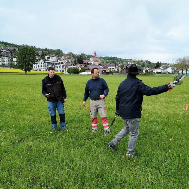 Markus Bättig, Thomas Hofstetter und Markus Hofstetter vermessen das Festgelände für den Musiktag Ruswil