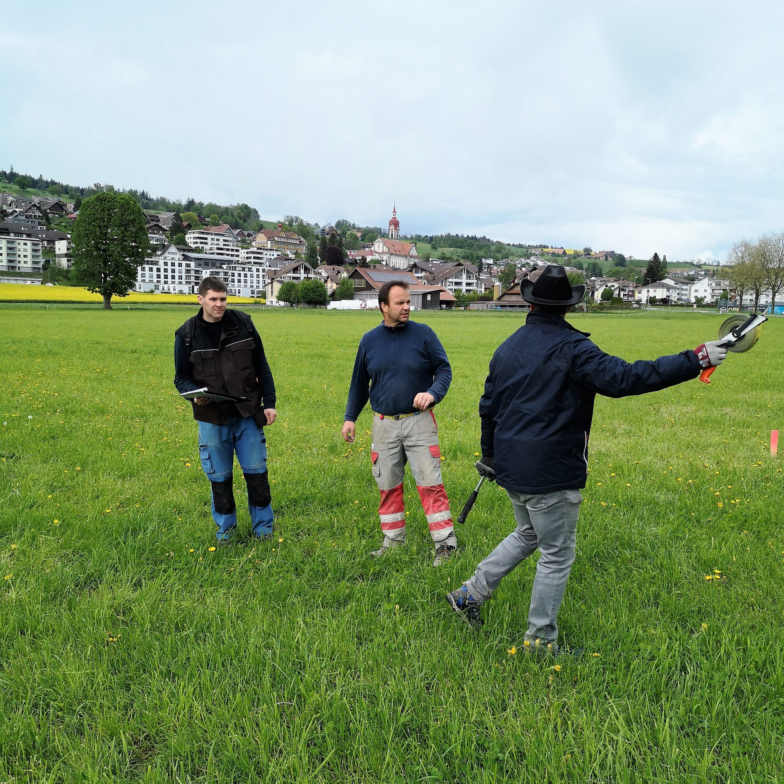Markus Bättig, Thomas Hofstetter und Markus Hofstetter vermessen das Festgelände für den Musiktag Ruswil