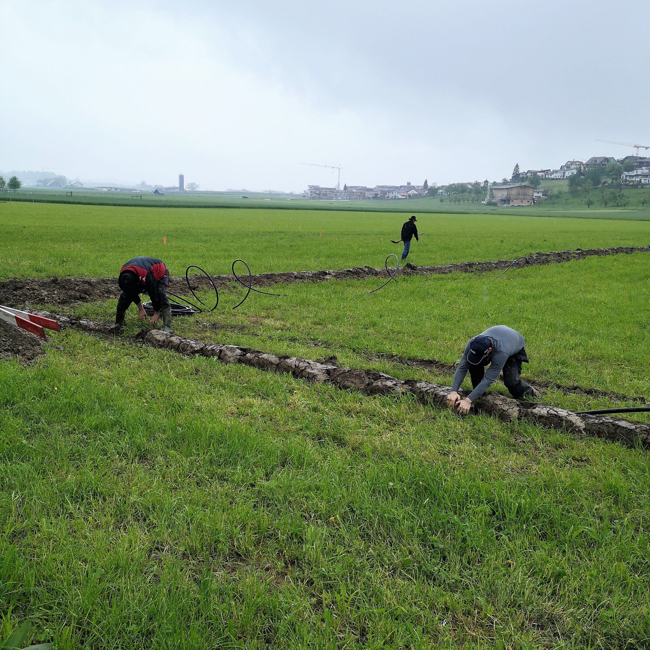 Beim Aufbau des Festareal für den Musiktag Ruswil werden die Rohre mit viel Handarbeit in den Boden verlegt.
