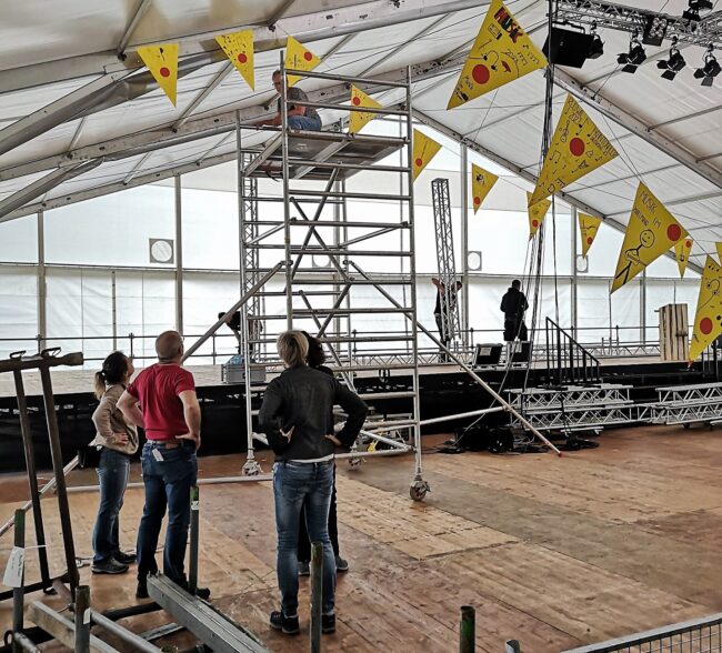 Das Deko-Team beginnt im Zelt die Fähnlein aufzuhängen, welche die Schüler extra für den Musiktag Ruswil kreiert haben.