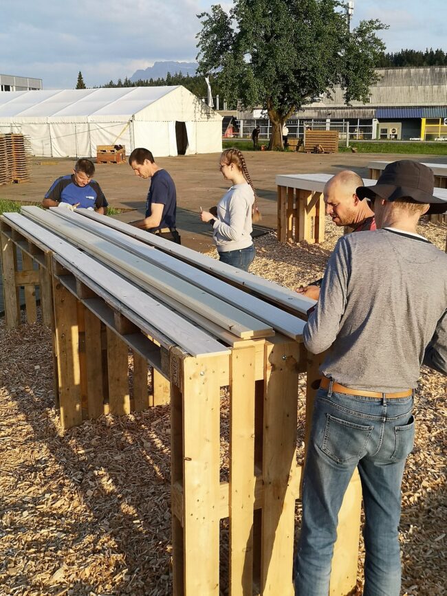 Die Musikanten setzen die Bartische zusammen, welche ein gemütliches Ambiente bei der Openair-Bühne garantieren.