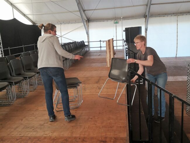 185 Stühle werden auf die Bühne gestellt, damit die Veteranen & Veteraninnen während der Ehrung sitzen können.